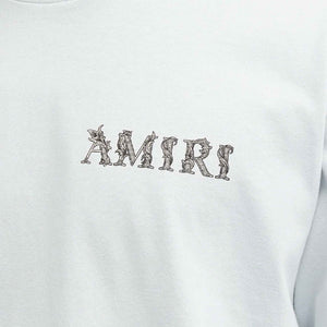 Amiri Baroque Logo T-Shirt in Gray DawnT-ShirtsAmiriDPUS191846552867SAmiri Baroque Logo T-Shirt in Gray Dawn