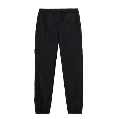 Stone Island black Nylon Metal Econyl crinkled trousers full front view showing elasticated waist and cuffs.