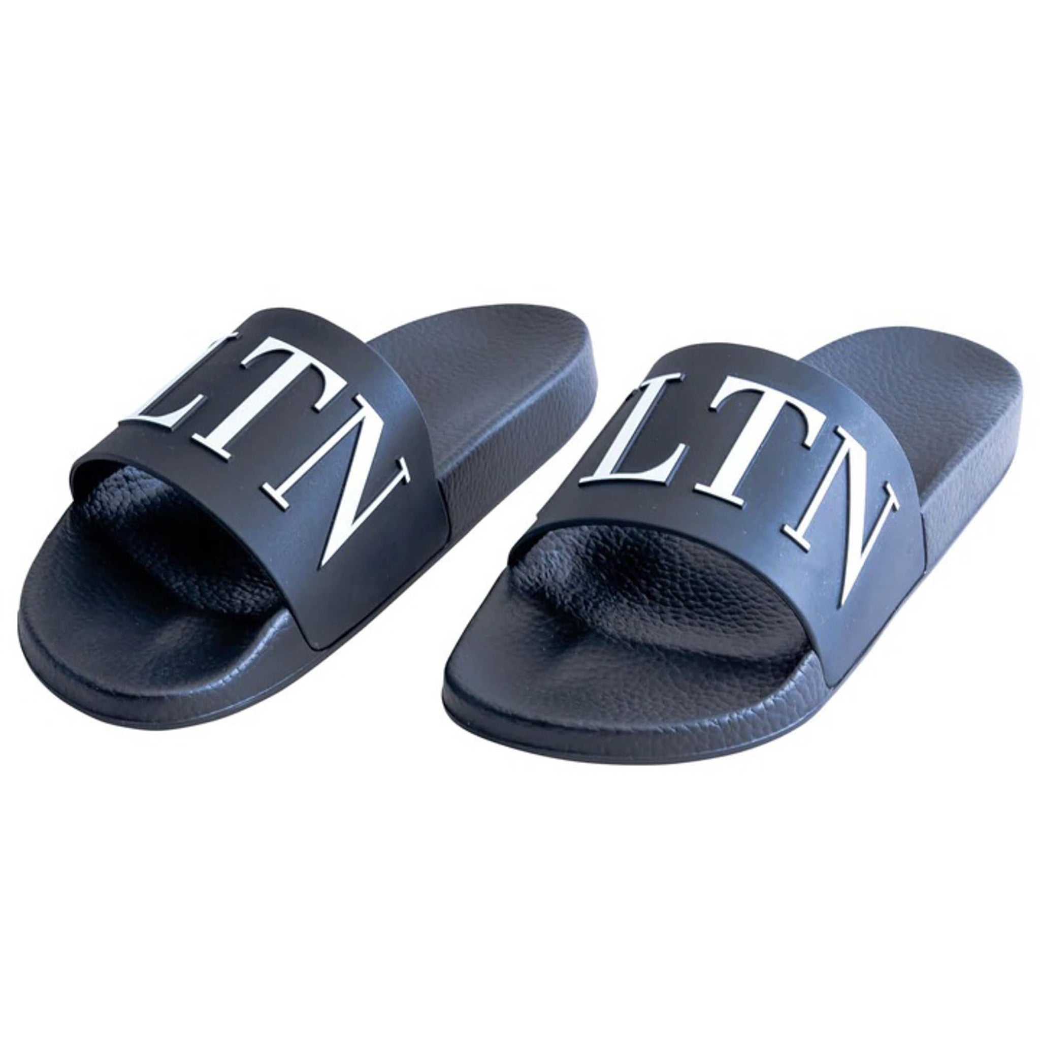 This stylish Valentino Garavani rubber sandal is perfect for any casual occasion. It features a bold VLTN band on the front, creating a standout finish. The sandal has a rubber sole for comfort and durability, and is made in Italy. It comes in a classic black colour and is part of the SS22 collection.